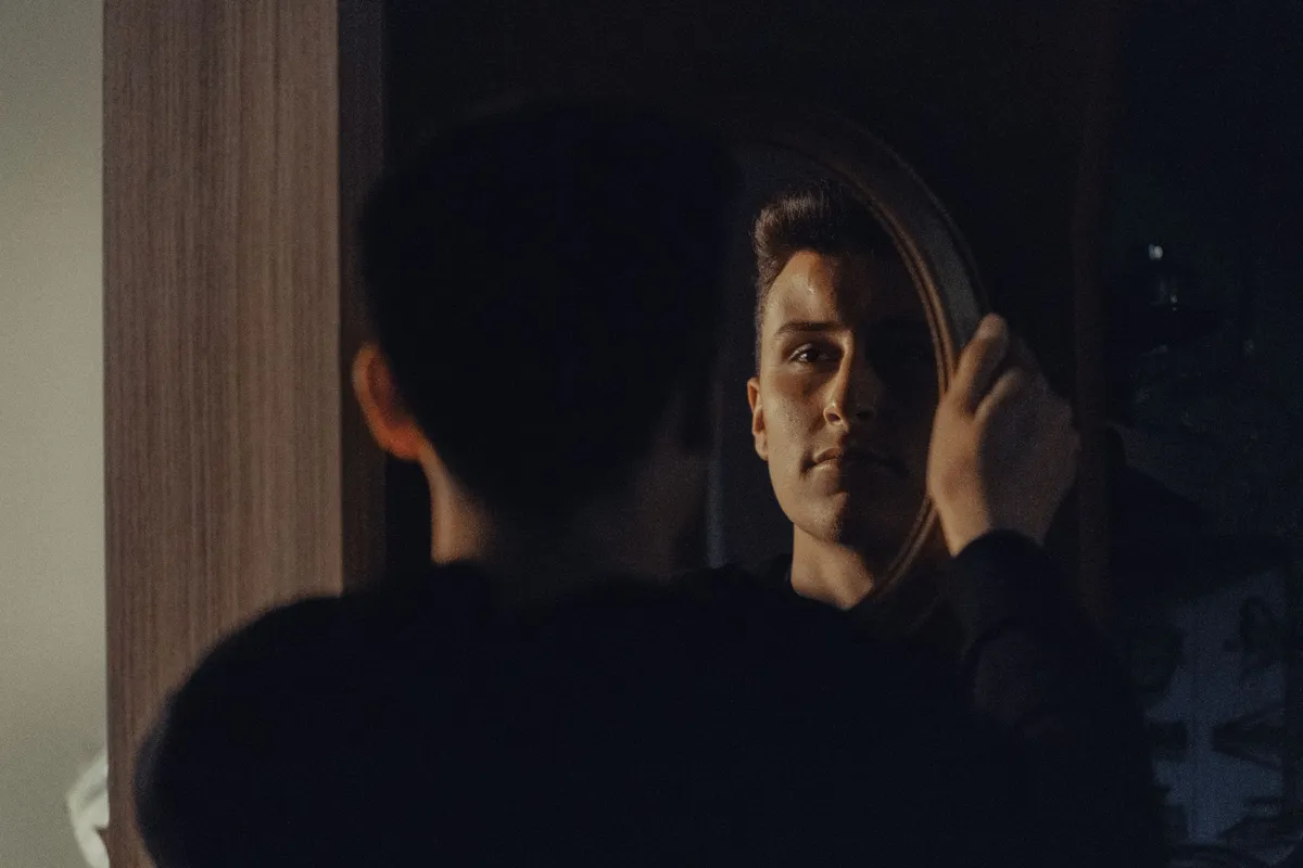 A man looking at his own reflection, asking am I the problem in my relationship