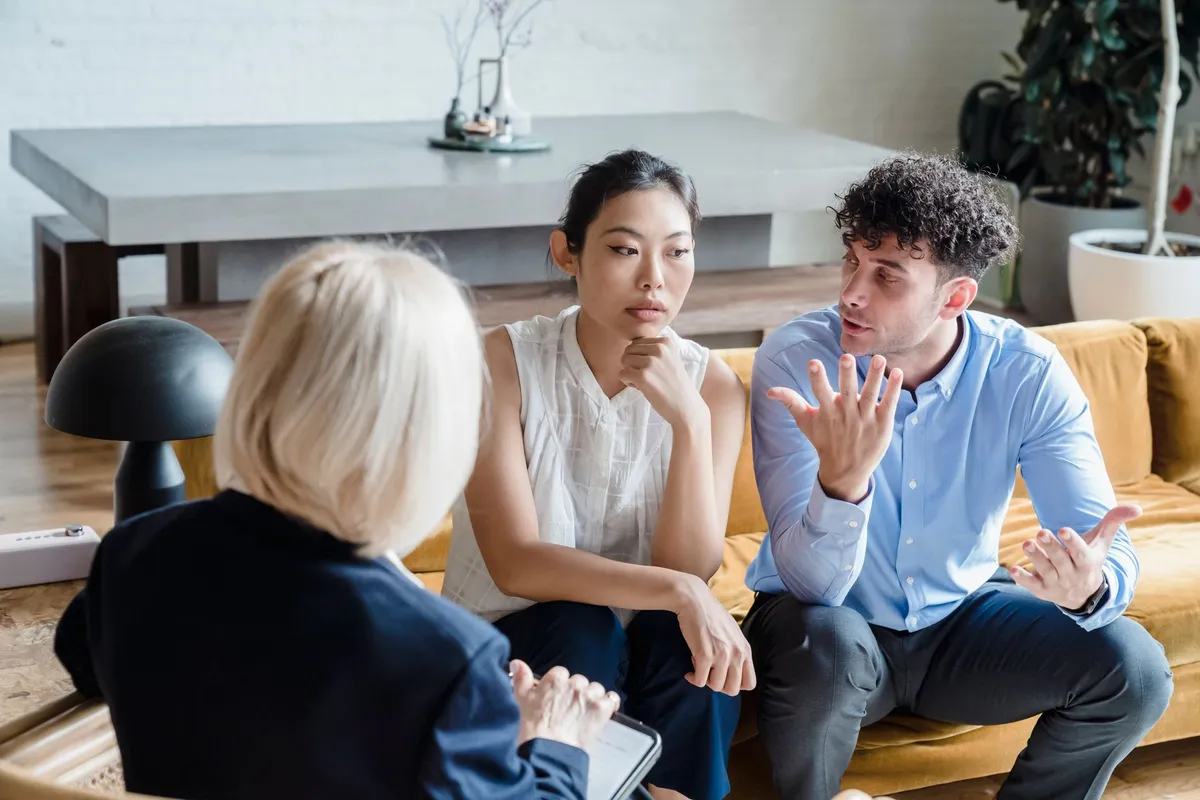 A couple sitting across from a counselor during a therapy session