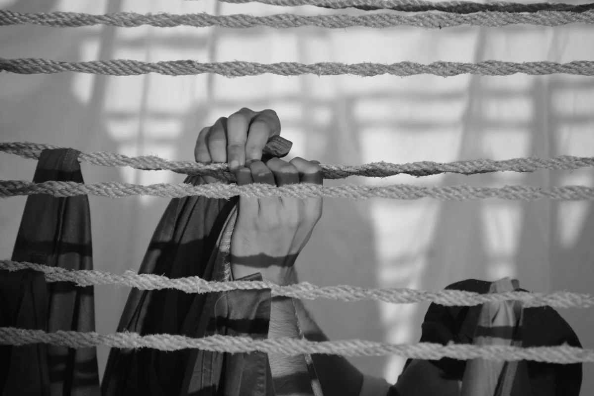 Hands gripping a rope under tension, the white-knuckle effort that cannot rebuild trust on its own