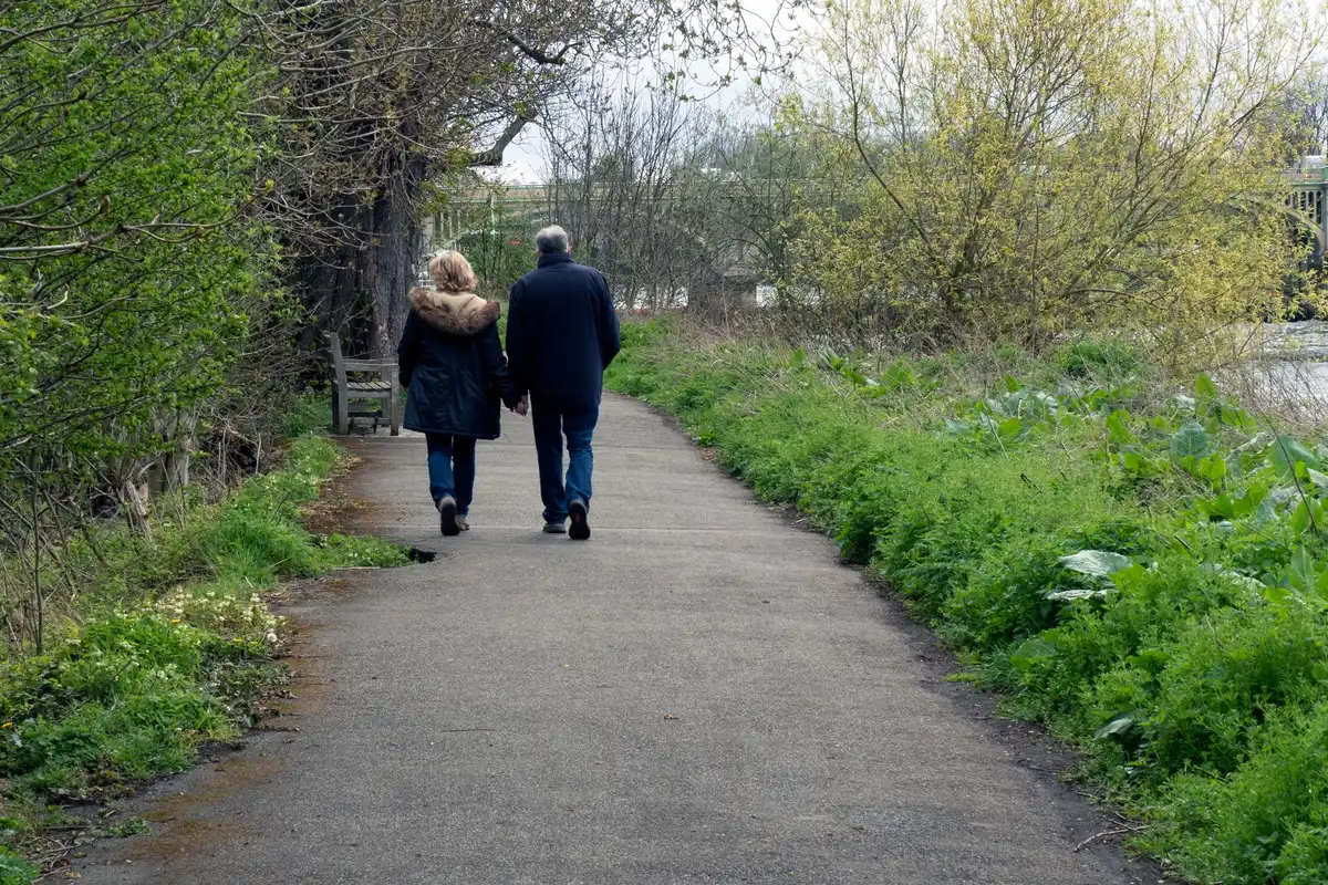 A couple walking side by side on a path, the shoulder-to-shoulder way men reconnect