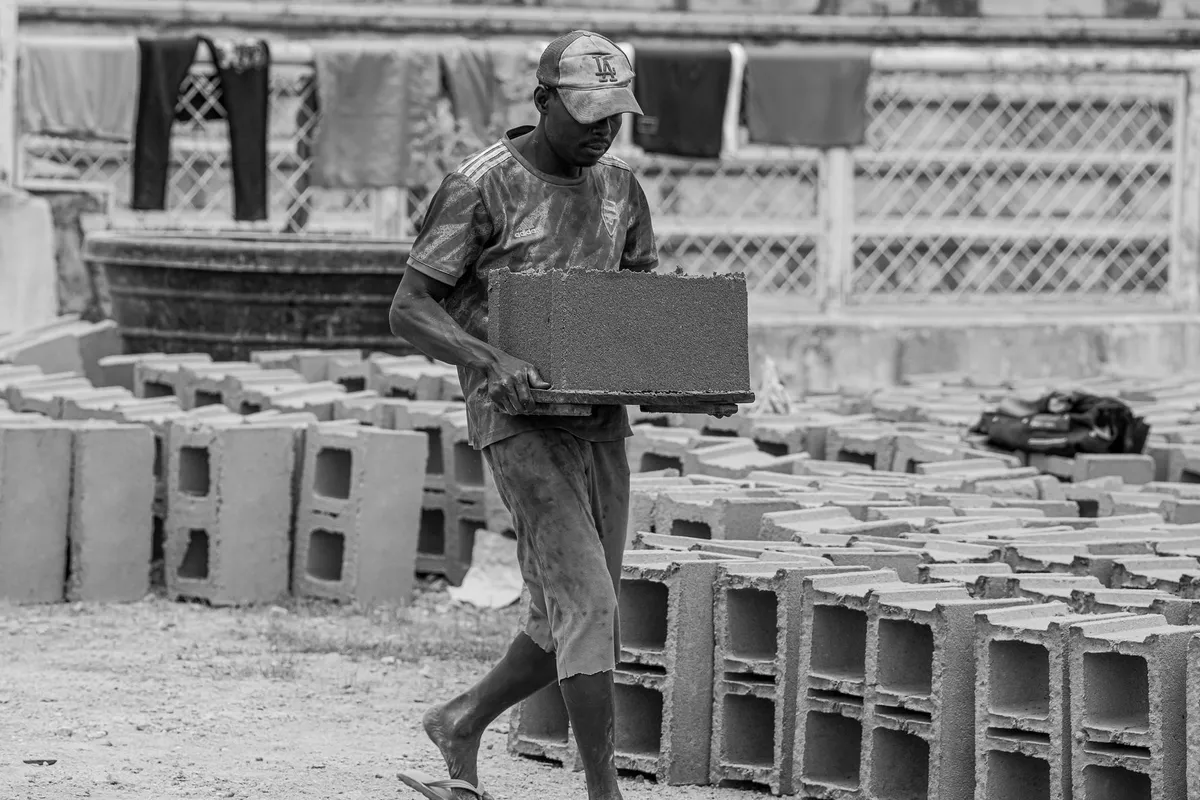A man carrying a heavy concrete block, the weight of resentment carried alone in a marriage