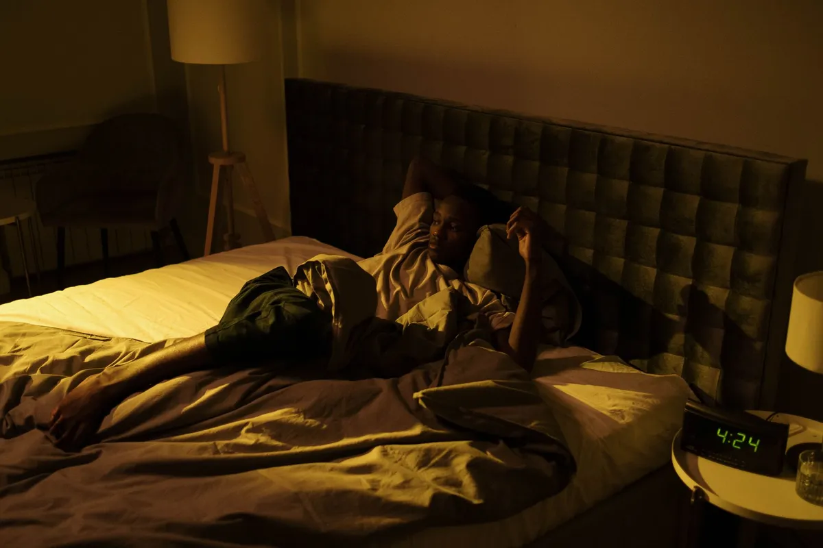 A man lying awake in bed at night unable to sleep