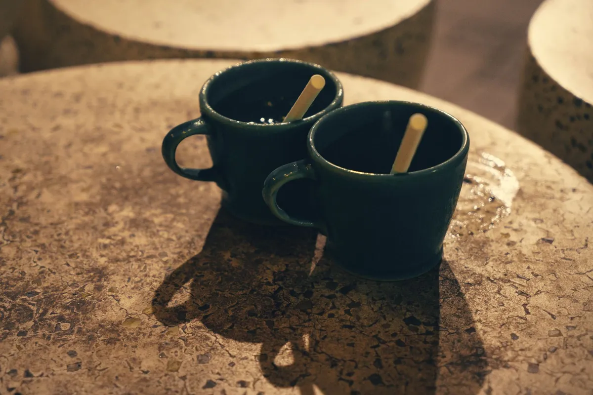 Two cups on a table in an empty room