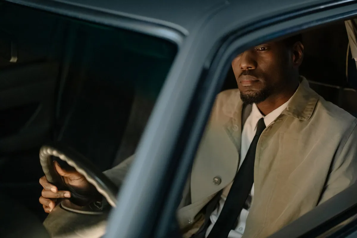 A man sitting alone in a parked car, the long quiet stretch before a walkaway husband leaves