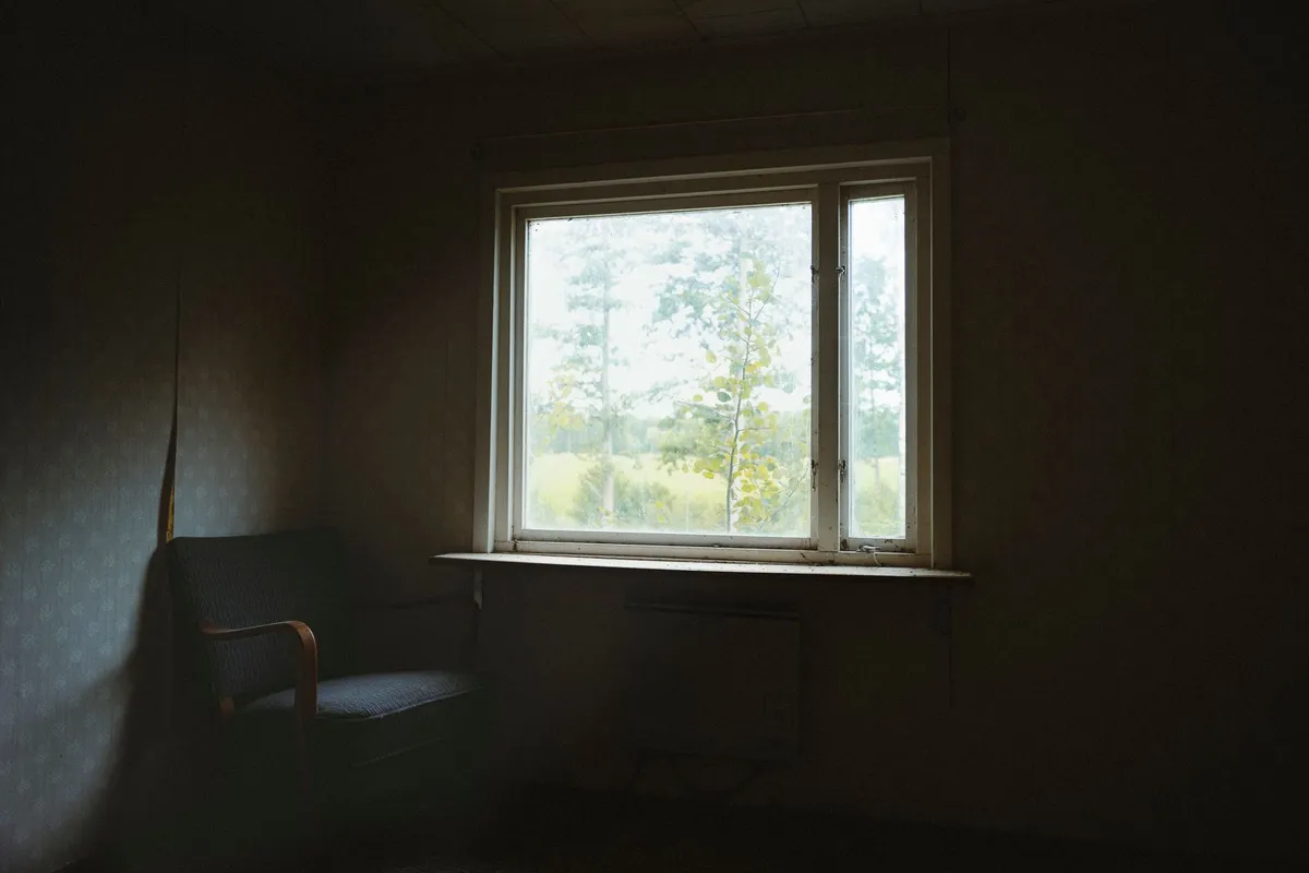 An empty chair beside a window in a quiet room